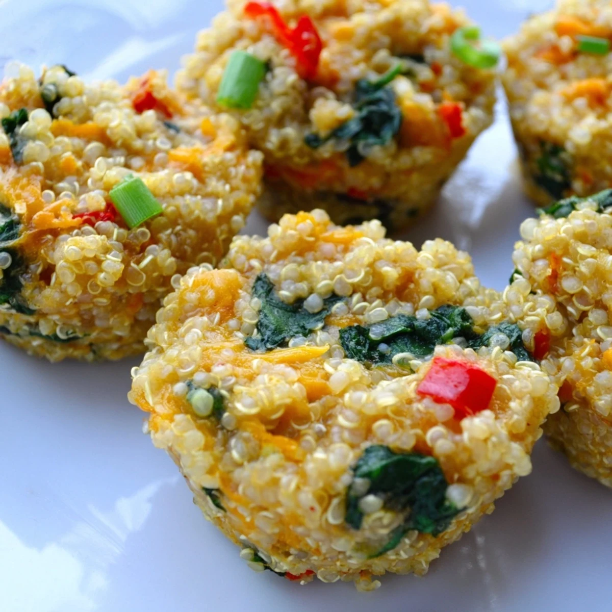 Golden baked cheddar quinoa bites with visible vegetables, perfect for a healthy snack or appetizer.