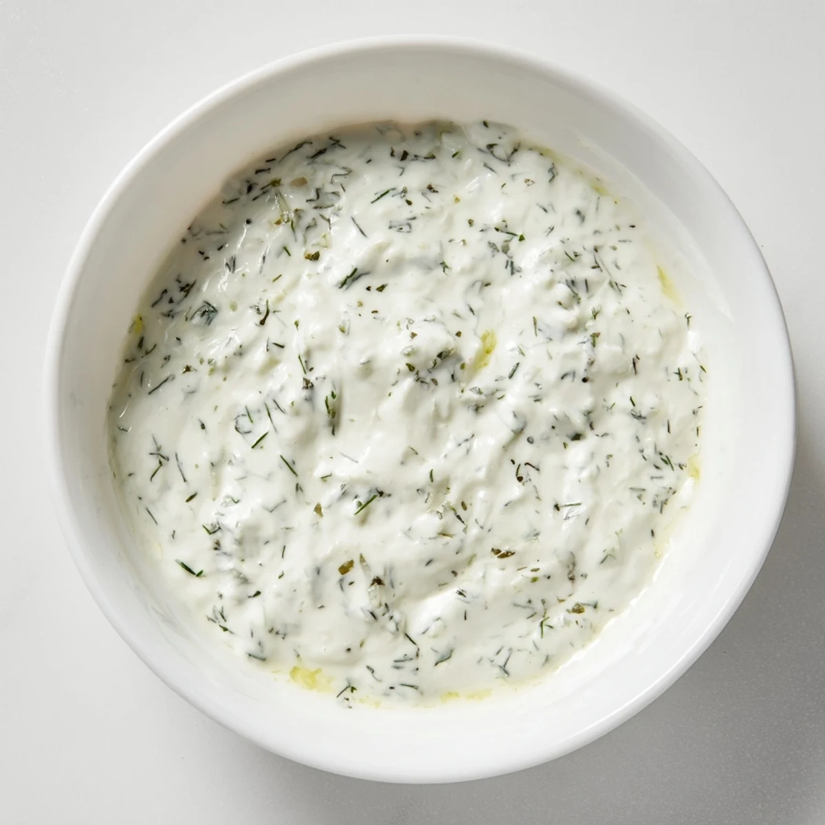 Creamy Greek Yogurt Ranch Dip, bursting with fresh herbs, is ready to be scooped with crisp veggies.