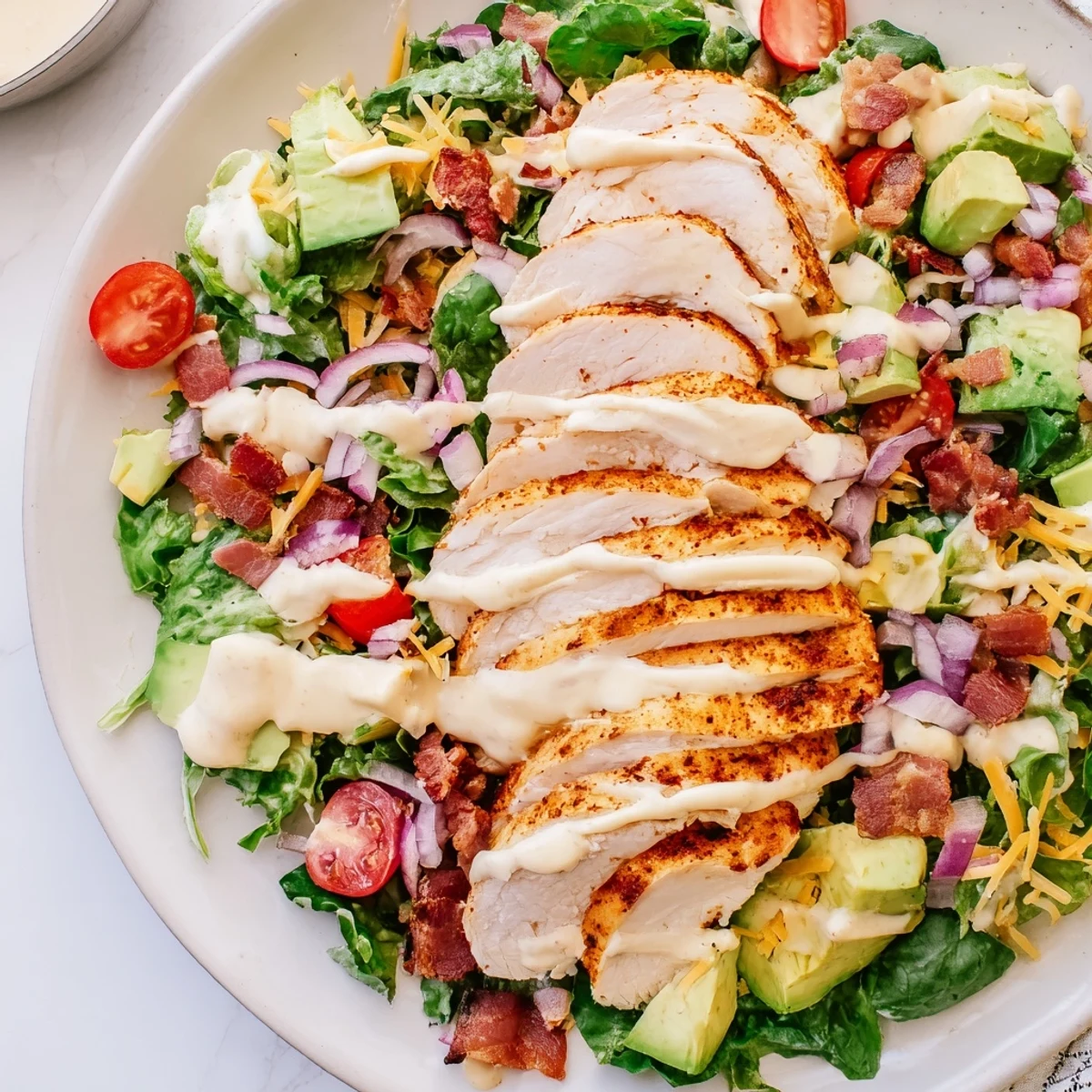 A delicious Crispy Bacon Chicken Salad with creamy ranch, fresh greens, and juicy cherry tomatoes.