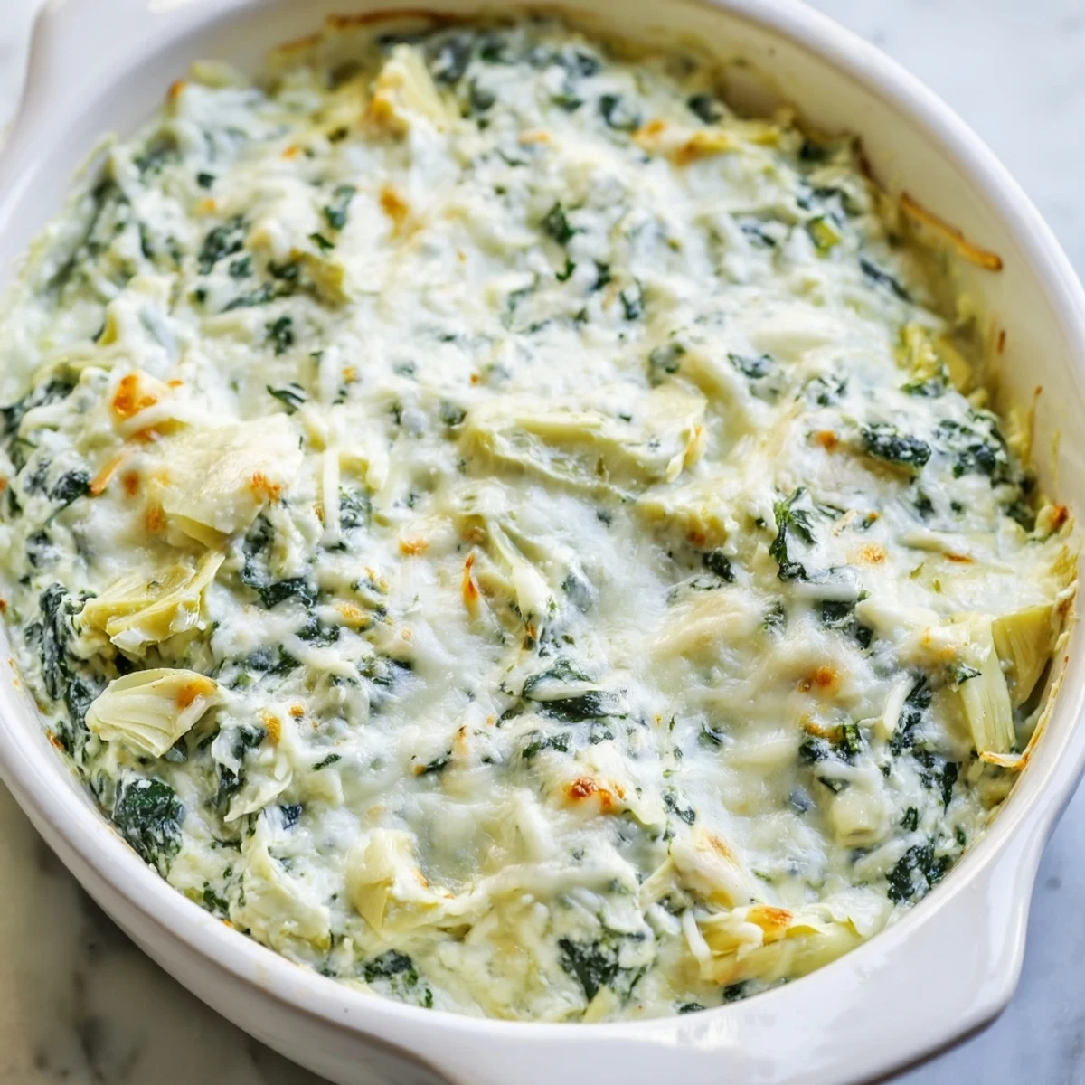 Warm bubbly Spinach Artichoke Dip, golden-brown and served with crispy tortilla chips.