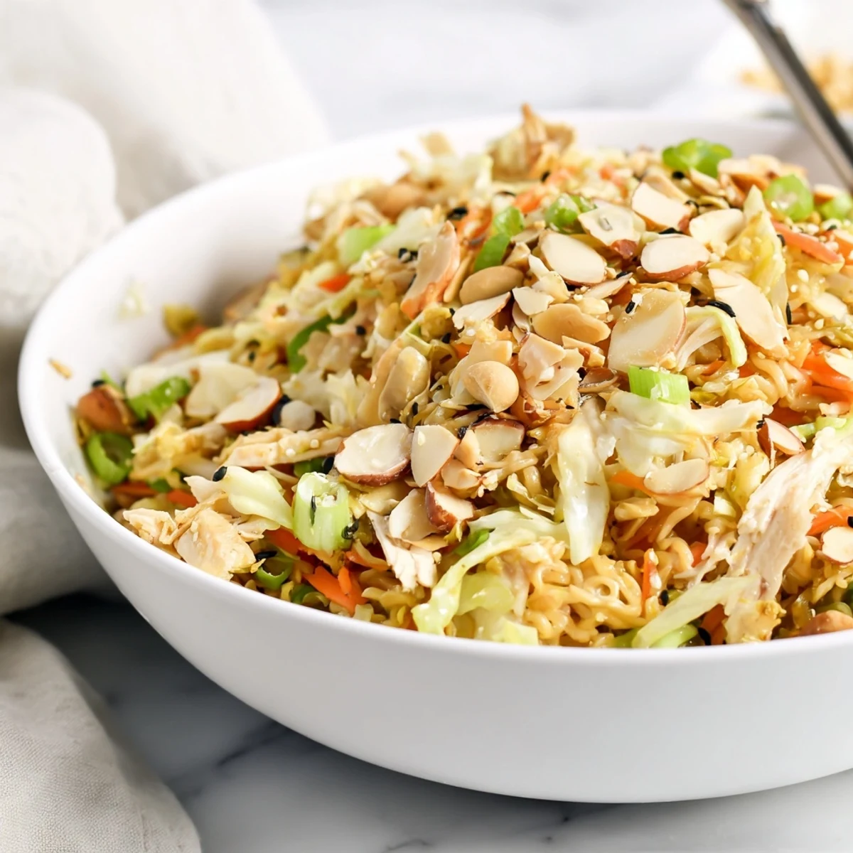 Crisp cabbage, tender rotisserie chicken, and crushed ramen noodles tossed in a sweet sesame dressing for a vibrant, crunchy salad.