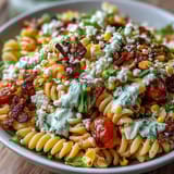 Creamy Mexican Street Corn Elote Pasta Salad featuring juicy cherry tomatoes, fresh cilantro, and a smoky chili-lime dressing.