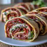 Vibrant Italian sub pinwheel wraps with layers of ham, salami, pepperoni, and provolone cheese rolled in tortillas.