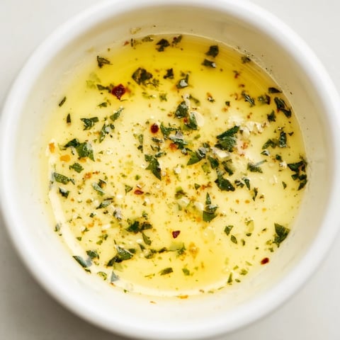 Golden Cowboy Butter Sauce with fresh herbs and lemon zest melting in a saucepan, ready to drizzle over steak or roasted veggies.