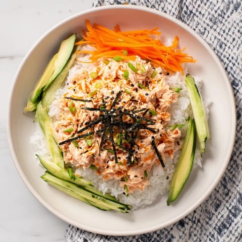 Flaky canned salmon tossed into a flavorful Spicy Canned Salmon Rice Bowl, served over hot rice with sesame seeds.