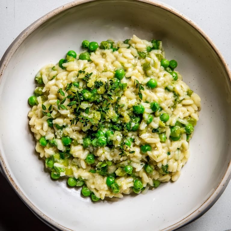 Bright and creamy Creamy Parmesan Orzo with Green Peas, garnished with fresh parsley, ready to eat.