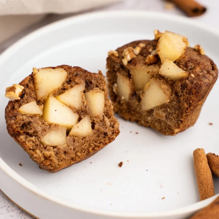 Freshly baked Seasonal Spiced Pear and Walnut Muffins, boasting visible pear chunks and crunchy walnuts.