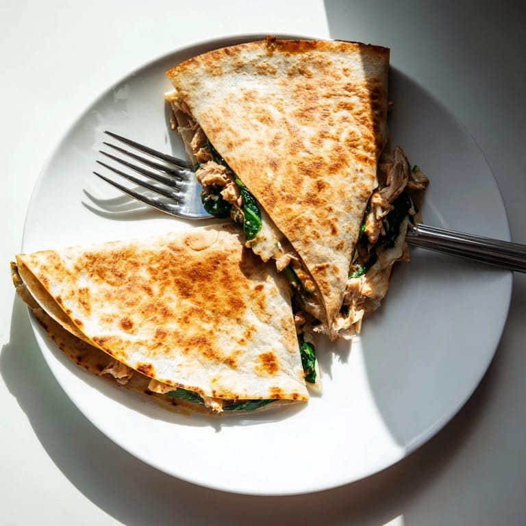 Warm flour tortilla wedges of Chicken and Spinach Quesadilla served with chunky salsa and guacamole on the side.